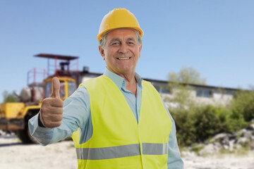 Wall Mural - Old constructor on building site making thumb-up gesture