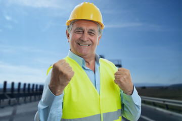 Wall Mural - Happy male constructor making celebrating gesture with fists