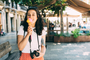 Wall Mural - Happy young beautiful tourist woman enjoying a big ice cream