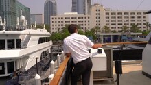 Ship Captain Master In Uniform Docking The Vessel Into Its Dock In The City Of San Diego, California On A Sunny Day
