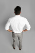 © New Africa - Businessman in formal clothes on grey background, back view