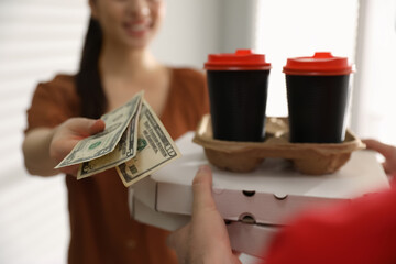 Canvas Print - Woman giving tips to deliveryman indoors, closeup