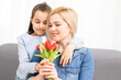 © Angelov - child daughter congratulates mother and gives a bouquet of flowers tulips