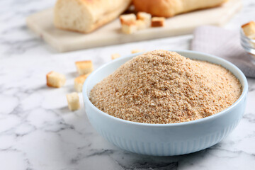 Fresh breadcrumbs in bowl on white marble table