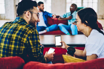 Poster - millennial male and female bloggers checking web information on blank smartphone gadget with copy sp