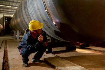 Asian workers are using flashlights to look at the details of the steel