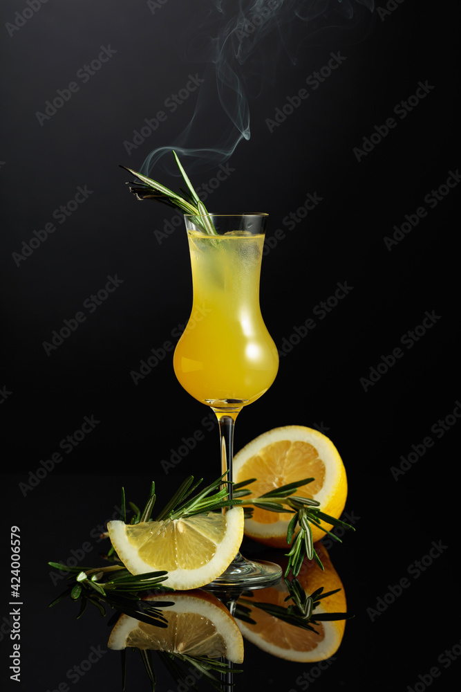 Traditional homemade lemon liqueur limoncello on the black background. - obrazy, fototapety, plakaty 