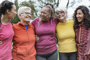 multi generational women having fun together at park - multiracial people meet and hugging each othe
