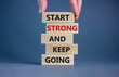 Start strong and keep going symbol. Concept words 'Start strong and keep going' on wooden blocks on a beautiful grey background. Businessman hand. Business, motivational and start strong concept.