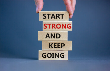 Wall Mural - Start strong and keep going symbol. Concept words 'Start strong and keep going' on wooden blocks on a beautiful grey background. Businessman hand. Business, motivational and start strong concept.