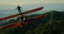 Stuntman Rides On Top Of Vintage Plane At Sunset, Aerial