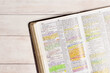 © pamela_d_mcadams - Used and Highlighted Bible Open on a White Wood Table