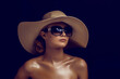Beauty photo of attractive woman wearing straw hat and big sunglasses posing on dark studio background