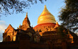 Reflection of sunlight on the golden stupas of temple complex in Bagan during sunset