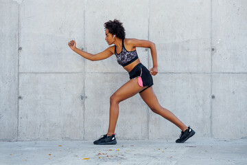 Afro athletic woman running outdoors.