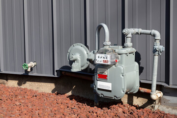 an angular view of a residential gas meter and pressure regulator mounted on the exterior of the hom