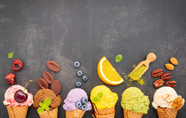Leinwandbilder - Various of ice cream flavor in cones blueberry ,green tea ,pistachio ,almond ,orange and cherry setup on dark stone background . Summer and Sweet menu concept.