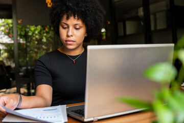 Wall Mural - african american woman planning business future, checking reports in the office. .