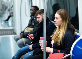 Portrait of thoughtful people traveling in modern city subway car in autumn day. Concept of daily city commuting