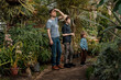 © Елена Григорович - Adventurous family inspecting tropical gallery in Botanical garden. Local travel