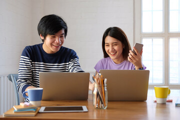 Two young designer working with computer laptop at creative workplace.