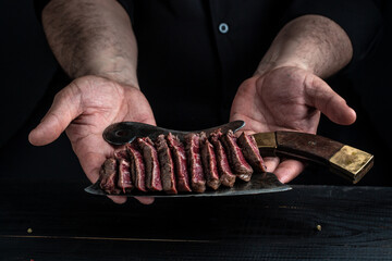 Juicy Beef rump steak from marble beef medium rareserved on old meat butcher, close-up. cooking meat steak by chef hands