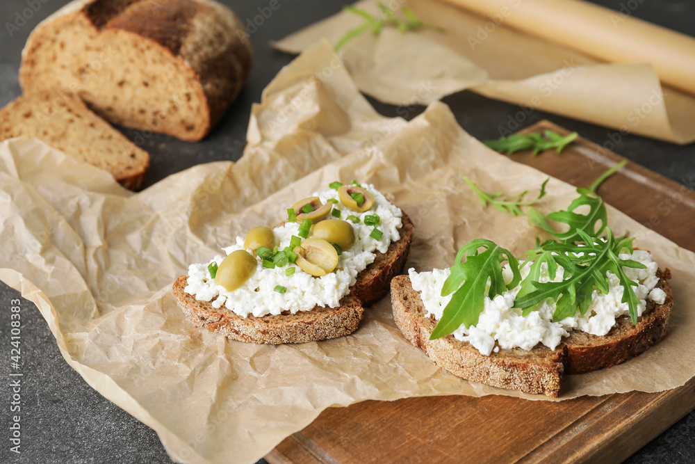 Tasty sandwiches with cottage cheese and olives on table