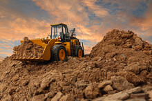Wheel Loader Are Digging The Soil In The Construction Site On The  Sky Background After Sunset