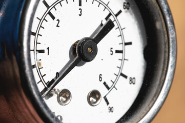 A close-up of a part of the white dial of an old manometer with an arrow at zero. Production stop and malfunction concept