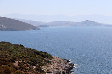 View to the Aegean sea and mountains with seaside town in mist. Turkish coast, beach vacation and travel concept