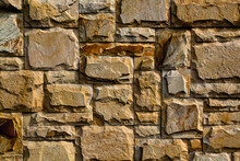Background Texture Of An Old, Yellow Stone Wall.