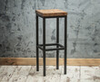 a sturdy high bar stool made of wood and metal in the loft or industrial style in the interior. Reliable support.