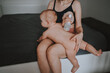 © Алина Троева - Young mother with newborn cute infant naked baby boy, holding him on arms, using breast pump hugging and breastfeeds with breast milk. Healthy child, concept of hospital and happy motherhood. Nursery.