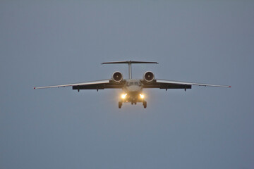 A passenger jet airliner is landing at sunset