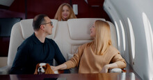 Happy Wealthy Family With Preteen Daughter And Cocker Spaniel Dog Flying Together On Private Jet