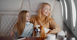 Mature mother and preteen daughter travelling on personal jet with dog