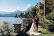 Walk for the newlyweds in a picturesque park on the shores of an Italian lake. Summer day.