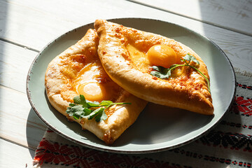 two Adjarian khachapuri in traditional classic Georgian style.