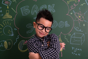 Asian Little boy in casual smile on blackboard.