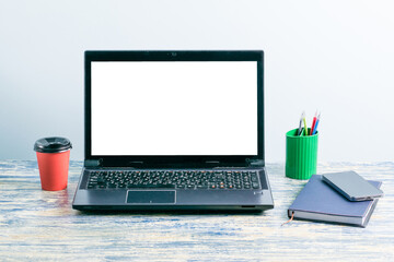 Wall Mural - Workplace with mockup letterhead on laptop screen, smartphone, notepad and pens, coffee or tea in paper cup on table