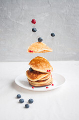 Wall Mural - Flying freshly cooked pancakes and berries with honey, walnut for breakfast.