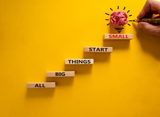 Wall Mural - Business concept growth success process. Wood blocks stacking as step stair on yellow background, copy space. Businessman hand. Words 'all big things start small'. Conceptual image of motivation.