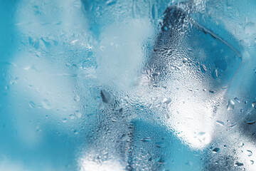 Ice cubes in a misted glass with drops of ice water close-up macro. Soft Selective Focus