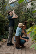 © Елена Григорович - Adventurous family inspecting tropical gallery in Botanical garden. Local travel