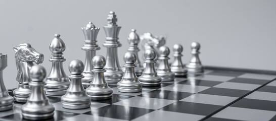 Wall Mural - silver Chess figure team (King, Queen, Bishop, Knight, Rook and Pawn) on Chessboard against opponent during battle. Strategy, Success, management, business planning, think,education and leader concept