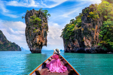 Wall Mural - Beautiful girl sitting on the boat and looking to James Bond island in Phang nga, Thailand.