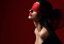 Profile Of Excited Woman With Naked Shoulders And Breast Holds And Eyes Covered With Red Scarf, Blindfold Over Dark Background With Copy Space. Fashion, Vogue, Sexy Stylish Look For Woman Concept
