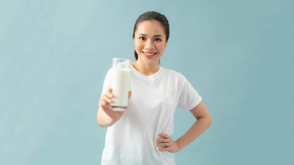 Happy young woman drinking milk