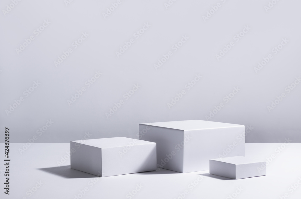 White square podiums in sunlight with shadow in white space. Showcase for cosmetic products, goods, shoes, bags, watches. - obrazy, fototapety, plakaty 