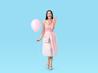 Poster - Beautiful young woman with balloon on color background